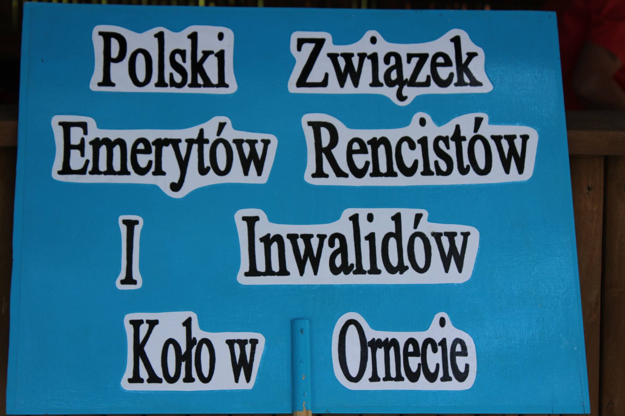 Napis na niebieskim tle Polski Związek Emerytów, Rencistów i Inwalidów w Ornecie