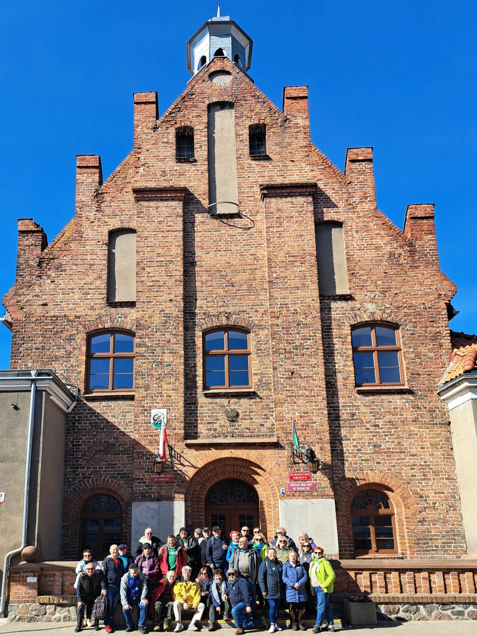 Grupa turystów przed Ratuszem miejskim w Ornecie
